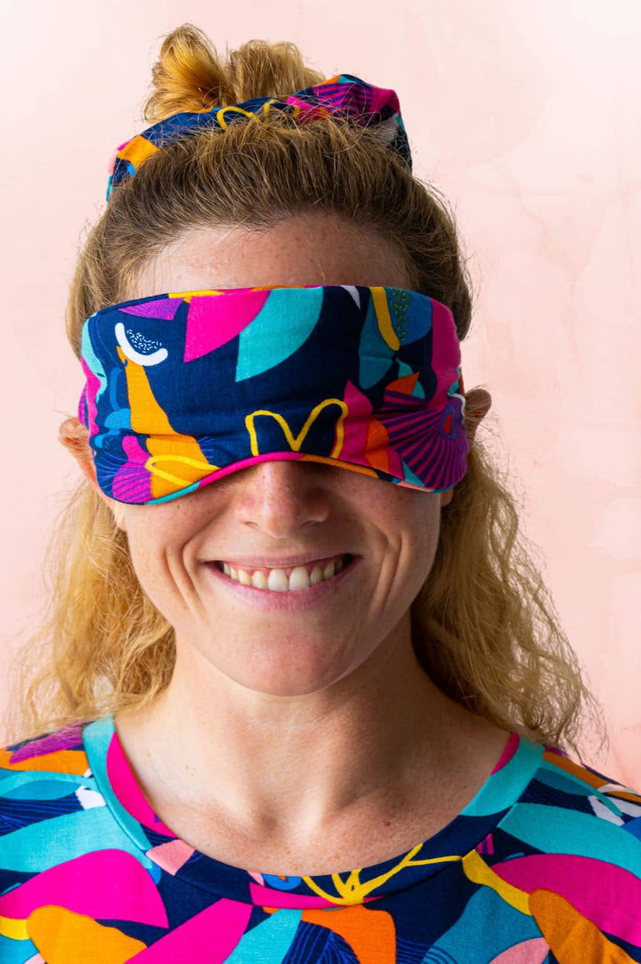 Model  smiling in kip and boo cancun print soft comfy bamboo eyemask for sleeping